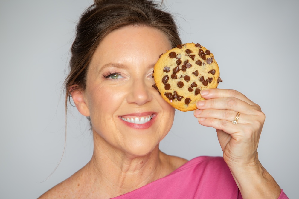 Stephanie holding a chocolate chip cookie — yes, you can still enjoy your favorite foods and be healthy